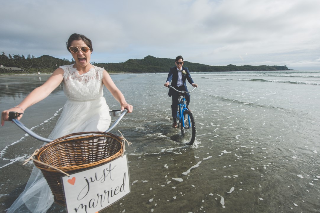 Wedding Couple Riding Bicycles on Beach West Coast Elope Vancouver Island Wedding Magazine