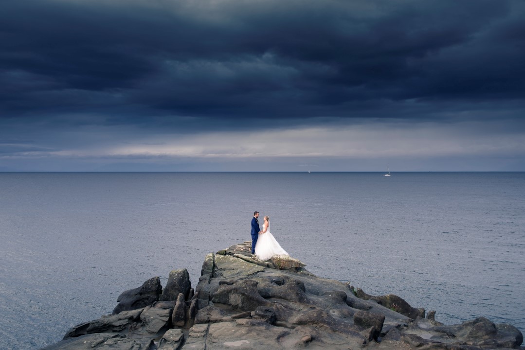 Newlyweds on Cliff Ocean View West Coast Weddings Magazine