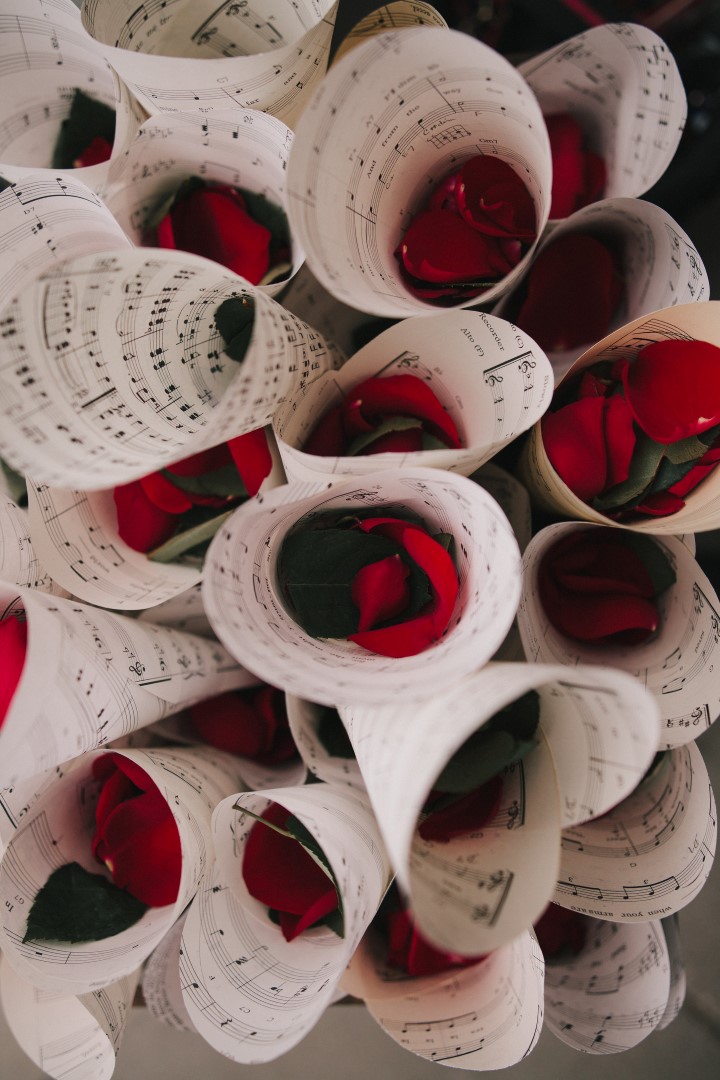 Red Rose Petals Wrapped in Vintage Music Sheets Gothic Dark Elegance West Coast Weddings Magazine