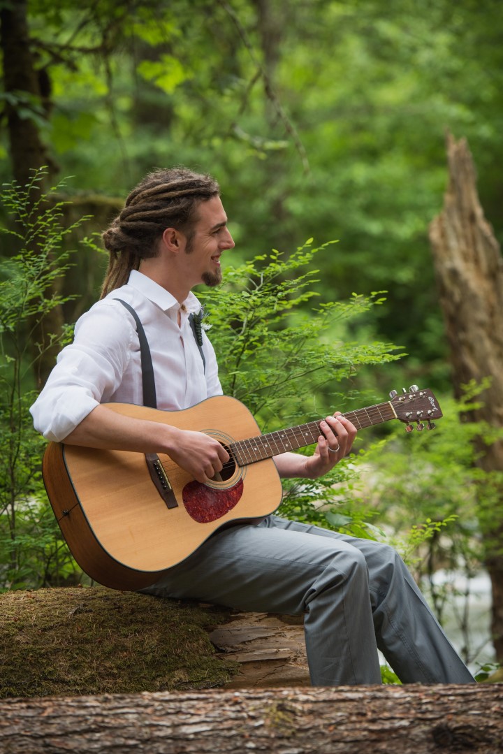 Groom playing Guitar in forest River Romance Vancouver Island wedding