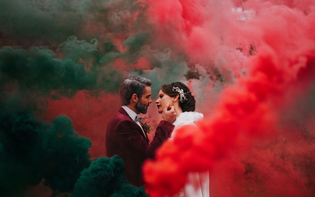 Newlyweds in red smoke bomb Holiday Glamour at Oak Bay Beach Hotel | Tasha Cline Photography | Beauty Bride | Cake by Taryn | Jennigs the Florist | Bliss Gowns & Events | Madison Paige Hair | Pretty Please Makeup Artistry | West Coast Weddings Magazine