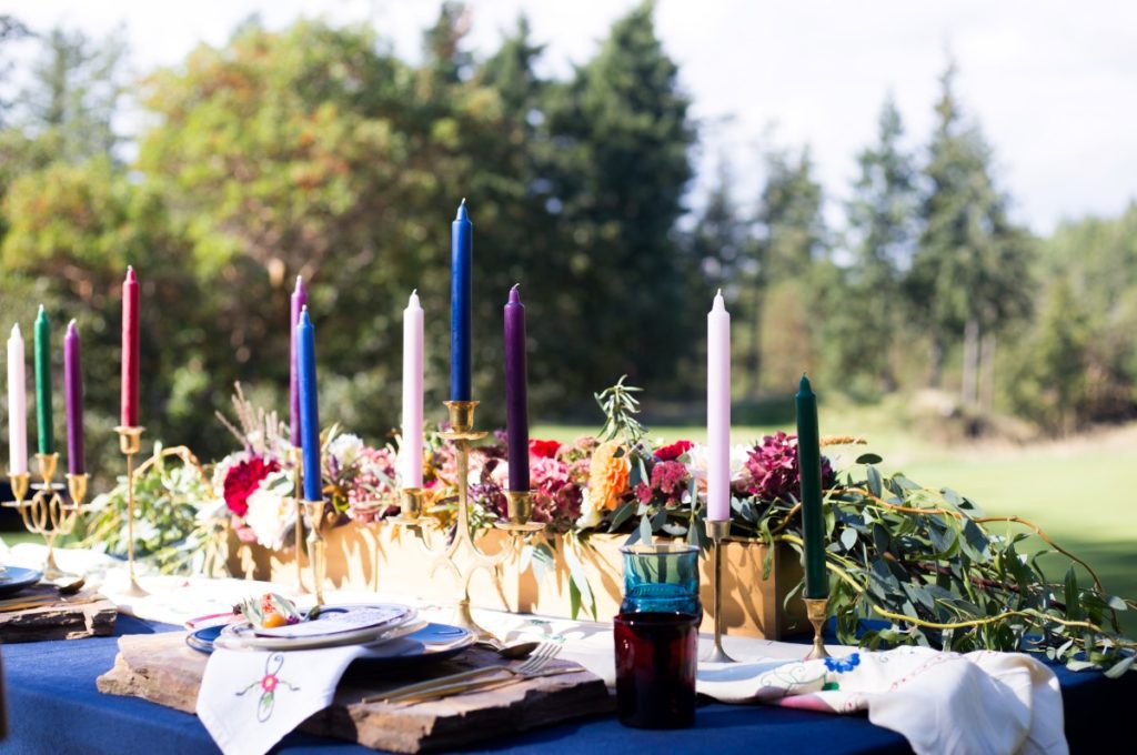 Spanish Style Coloured Candles on Outdoor Reception Table Vancouver Island Wedding Magazine