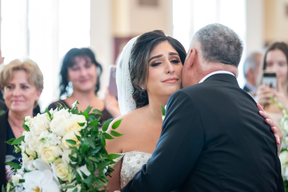 Bride and father hug at the front of Vancouver Church