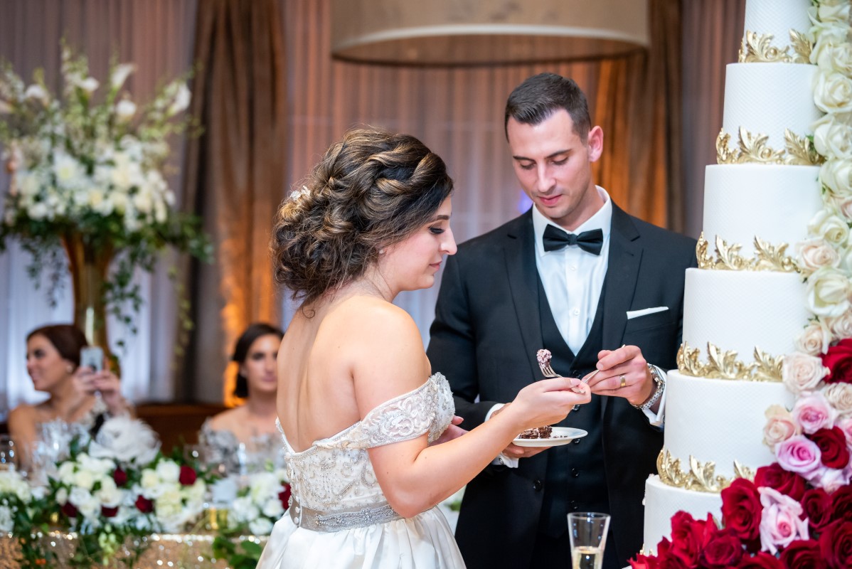 Newlyweds cut the five tier beige and gold wedding cake at Vancouver Club