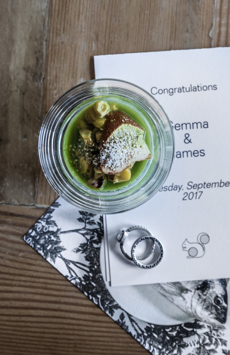 Appetizer sits atop wedding invitations on wedding reception table