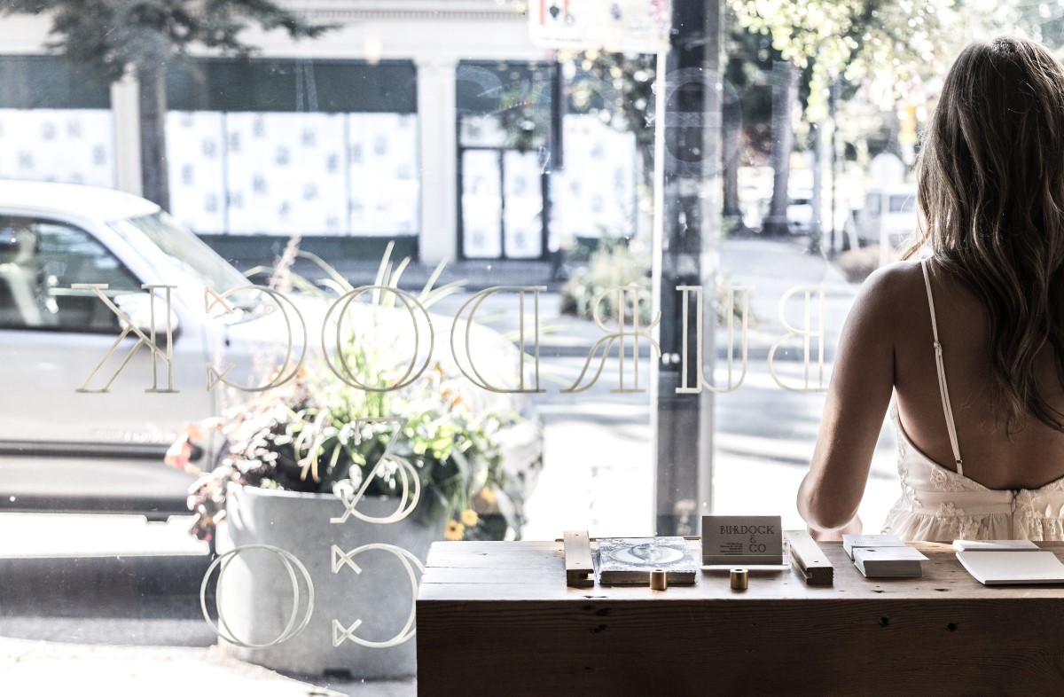 Chic bride looks out into city street through window