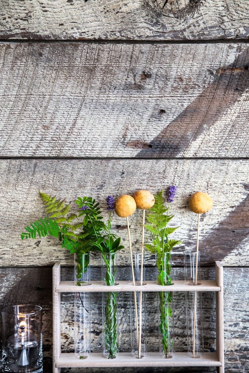 tulips and ferns in glass test tubes against distressed wall by Studio Full Bloom Vancouver Wedding