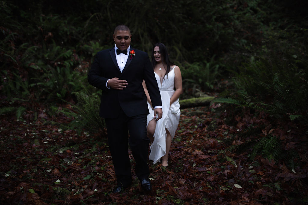 Waterfall Bride and Groom walk through the forest holding hands Vancouver Island