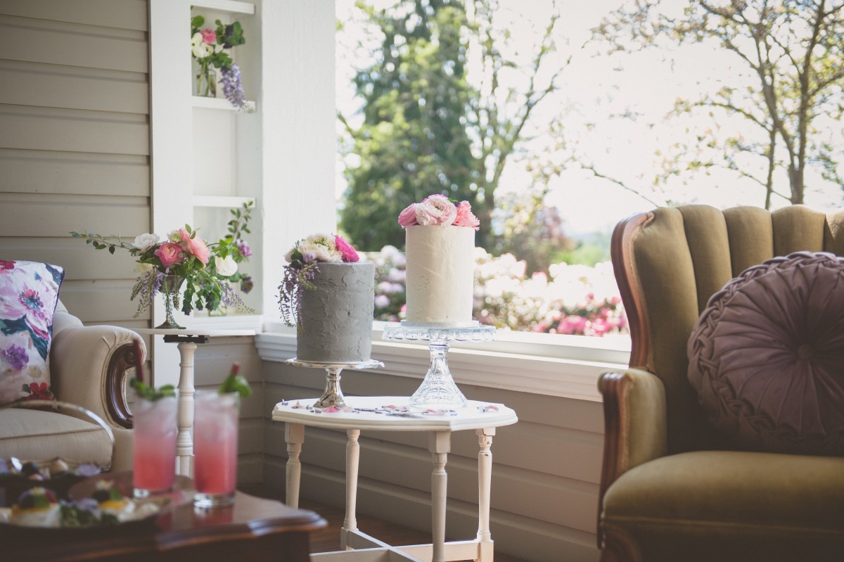 White and grey wedding cakes topped by fresh flowers on heritage house outdoor garden Maple Bay Manor