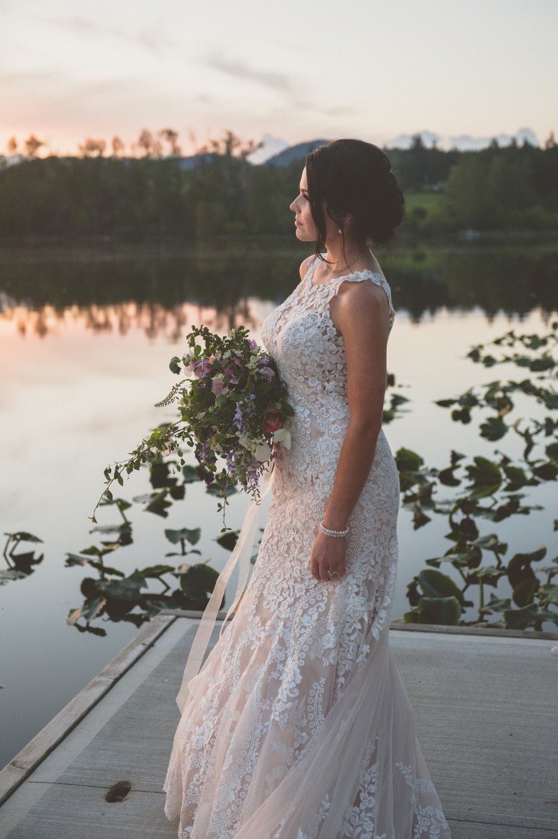 Bride on Lake Deck surrounded by water lilies and sunset Cowichan Bay Weddings