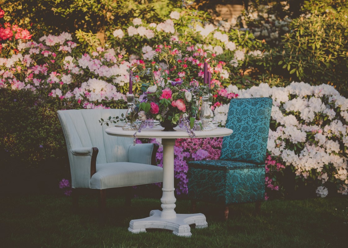 Table and two antique chairs in flower garden for wedding reception on Vancouver Island