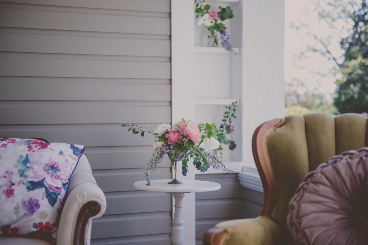 Florals sitting on side table with antique furniture West Coast Weddings