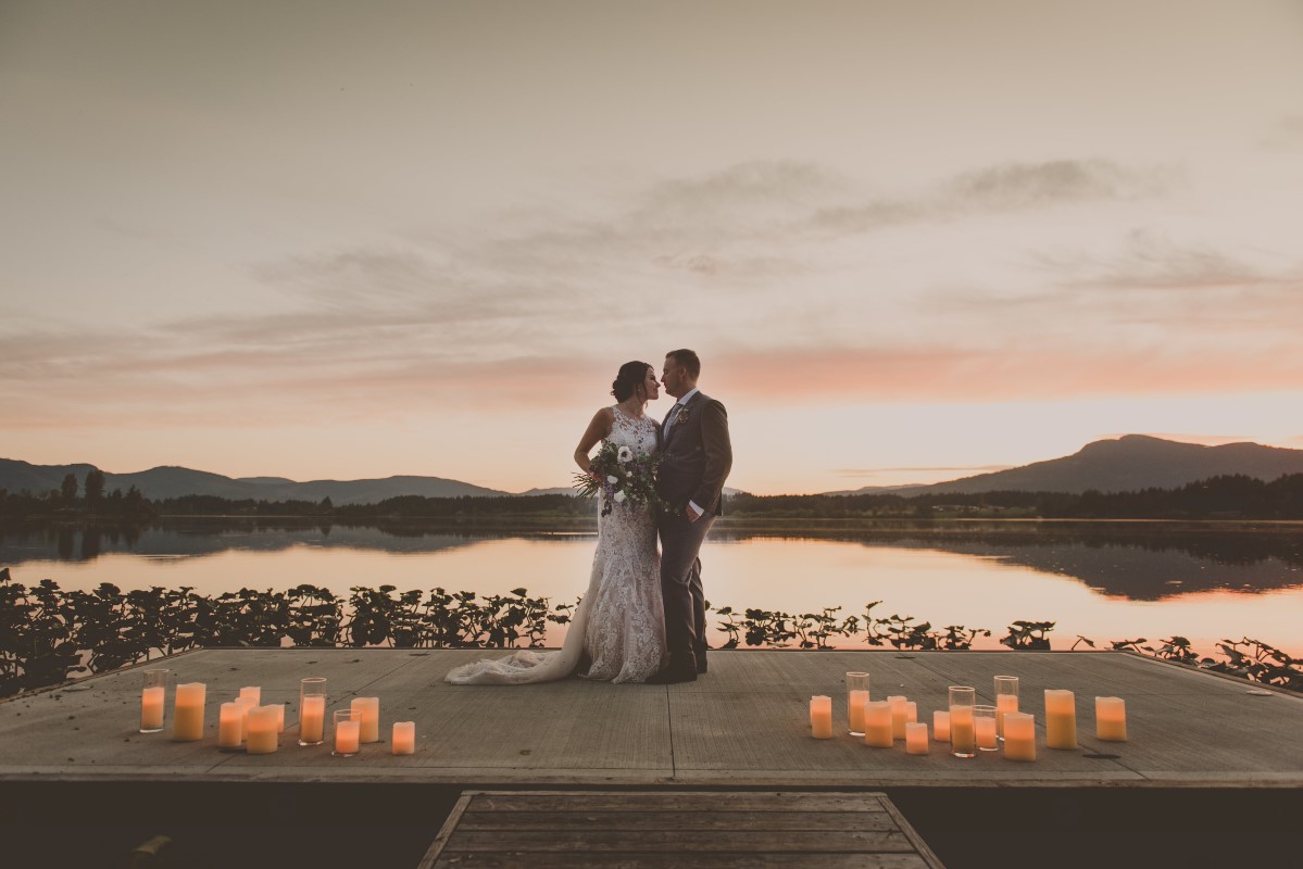 Couple in front of lake sunset surrounded by candles Vancouver Island Weddings