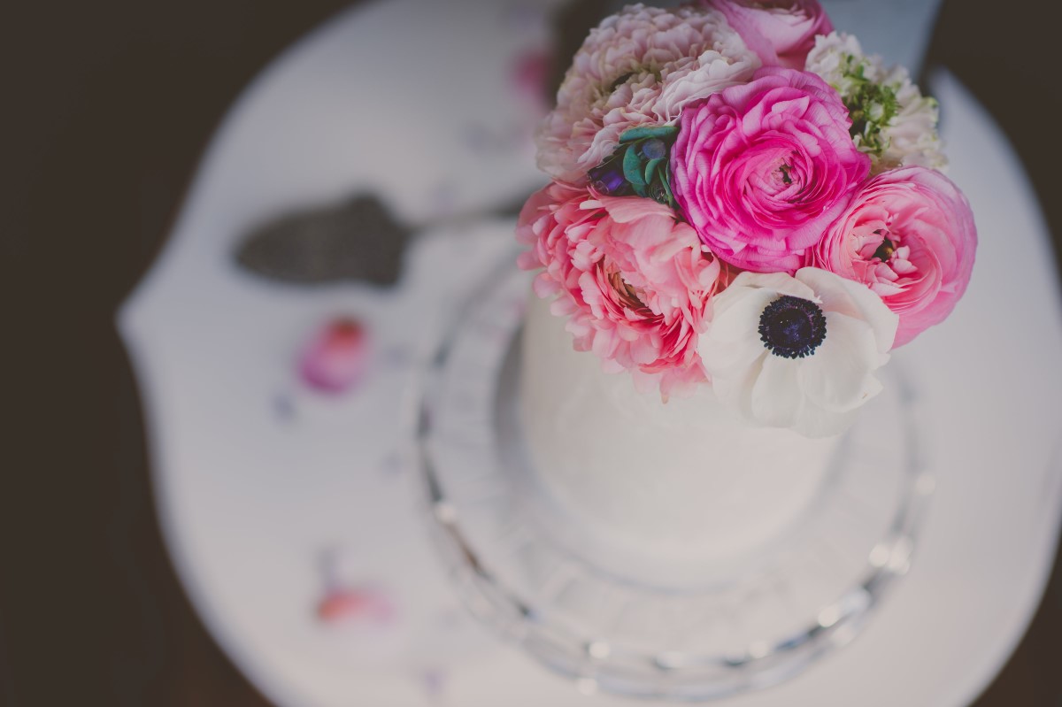 Pink flowers on white wedding cake and vintage plate Cobblehill Cake Co