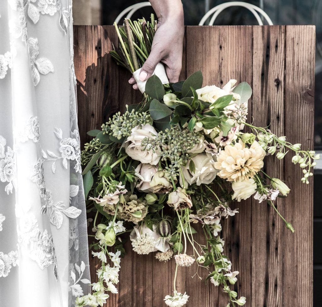 White bridal bouquet and lace overlay Park and Fifth Co wedding gown in Vancouver