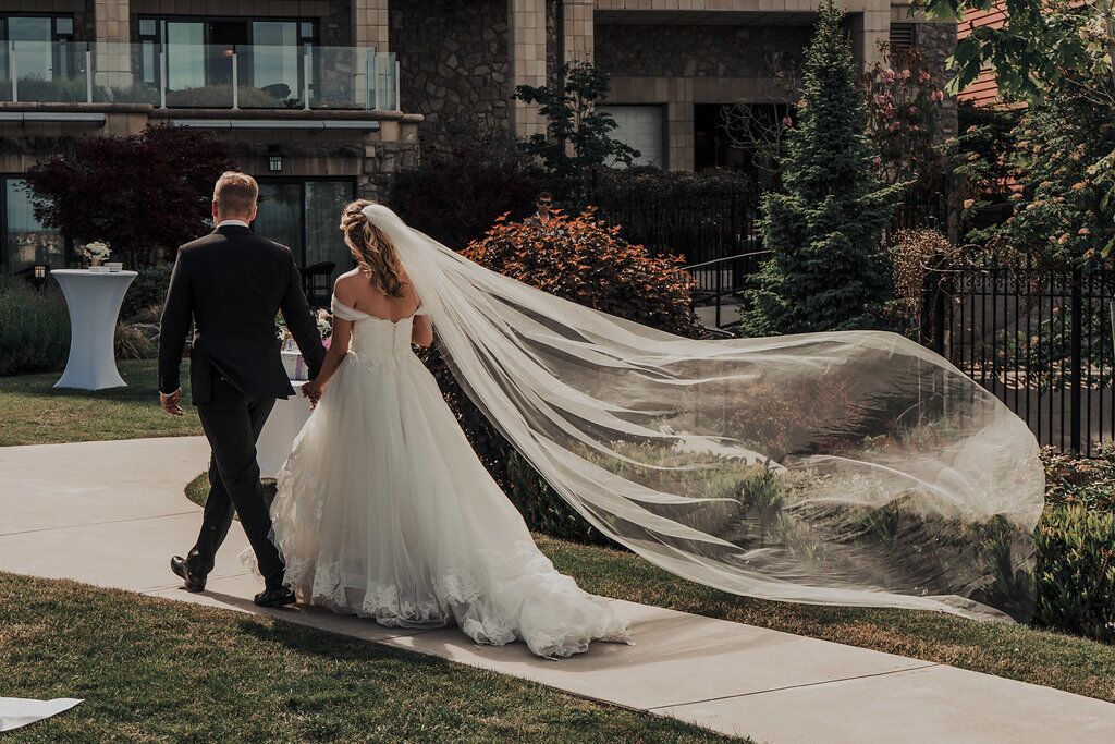 Newlyweds leave ceremony with bride's veil flying in the breeze