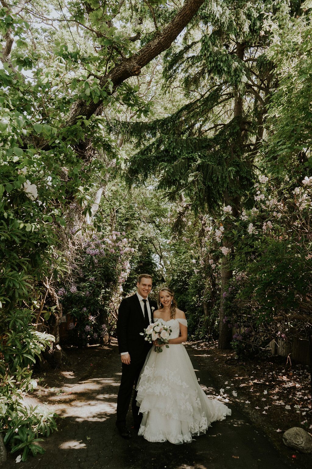 Romantic newlyweds under tree cover at Oak Bay Beach Hotel