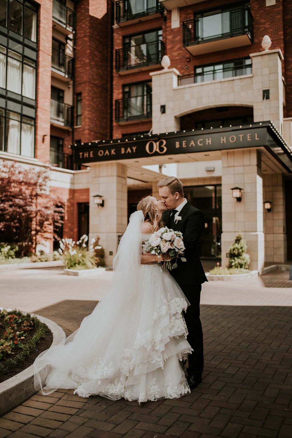 Romantic Newlyweds kiss at front door of Oak Bay Beach Hotel