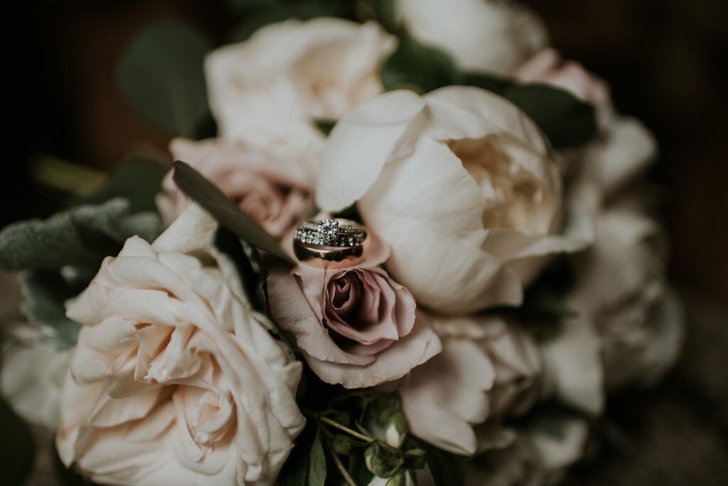 Romantic wedding rings on blush roses West Coast Weddings Magazine