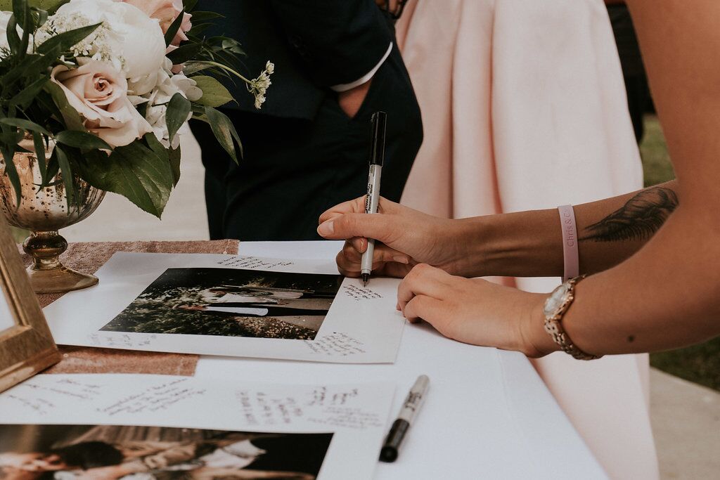 Guests signing photos of the newlyweds at wedding reception on Vancouver Island