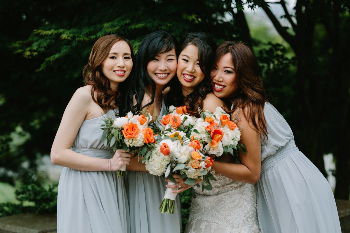 Chinese Fusion Wedding bride and bridesmaids in pastel dresses with orange and white bouquets