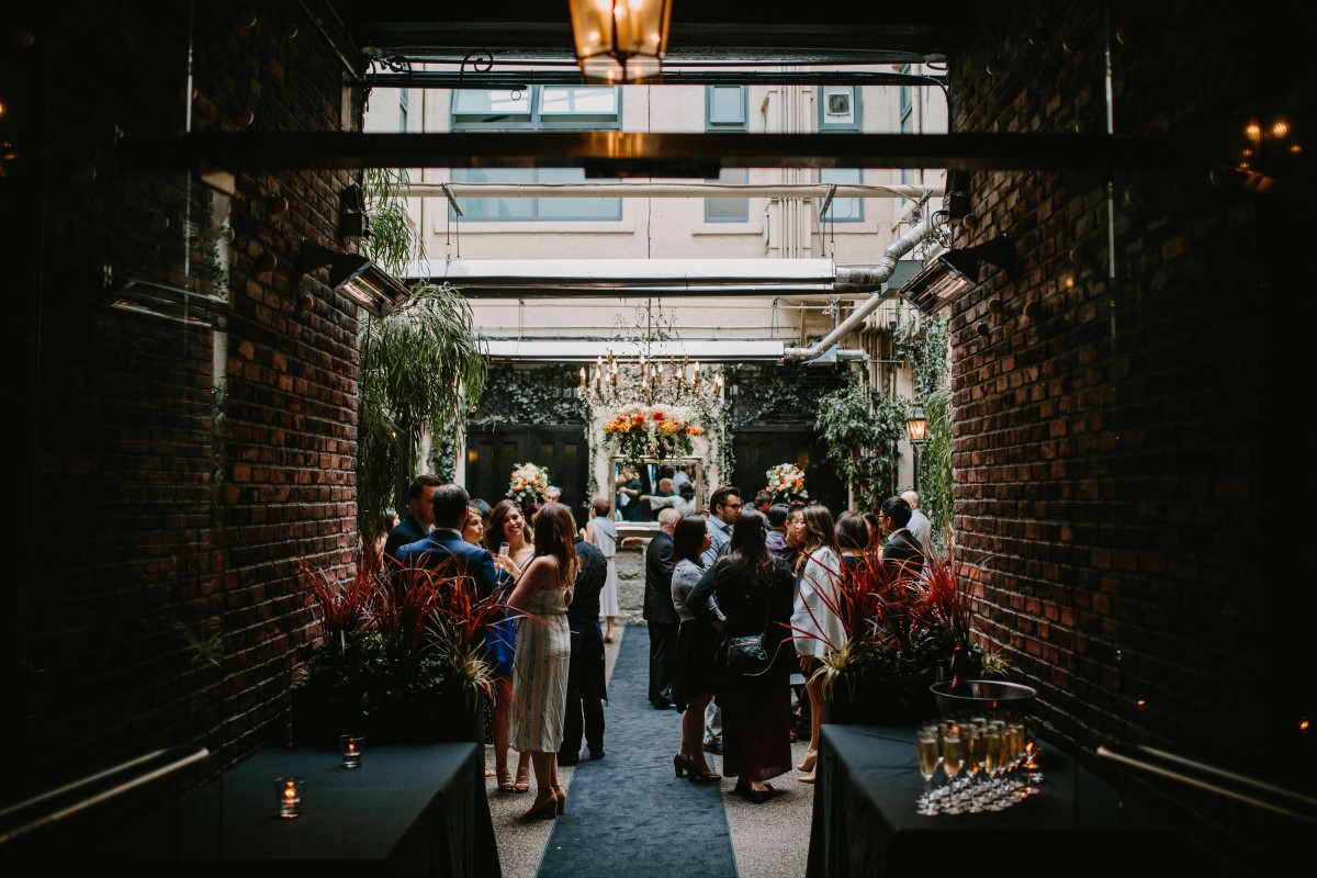 Chinese Fusion Wedding Couple exchange wedding vows in front of ivy backdrop in Vancouver