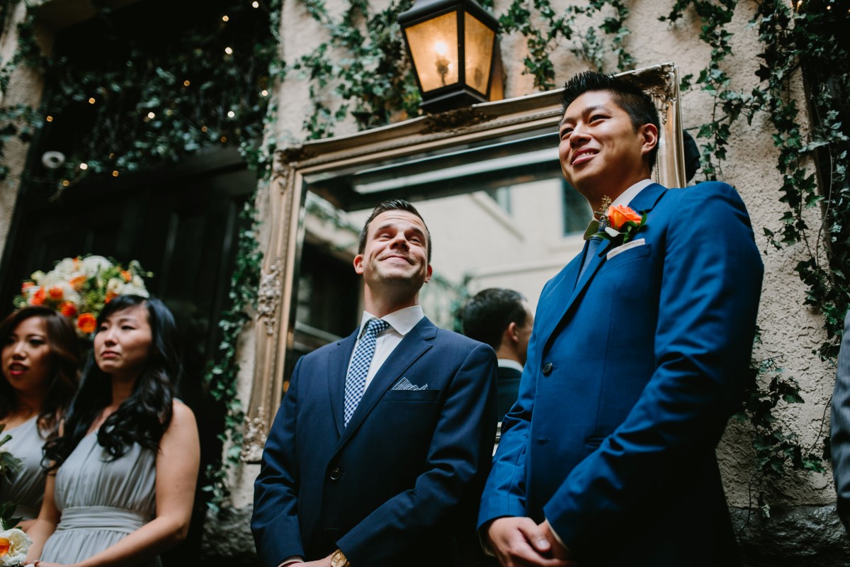 Groomsman in blue suits watch wedding ceremony in Vancouver