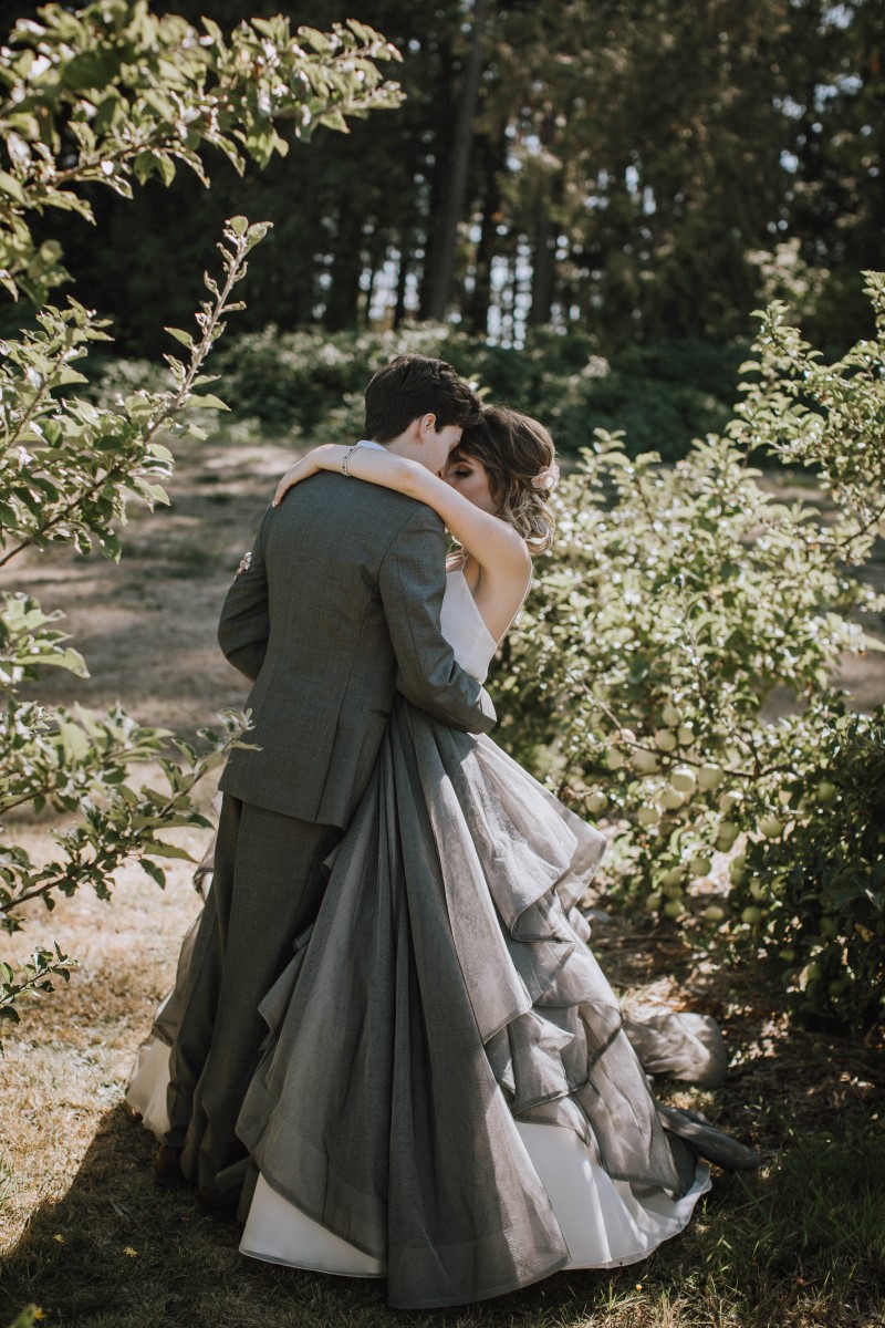 Newlyweds kissing on forest path at Sea Cider Vancouver Island