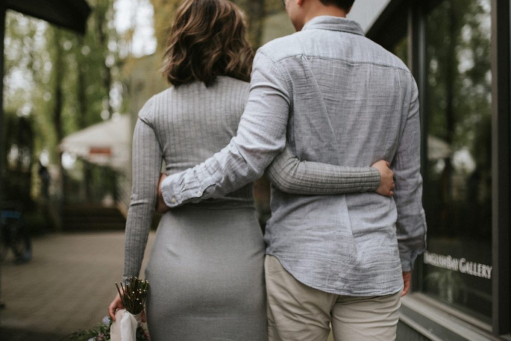 Couple with arms around each celebrate engagement in Vancouver