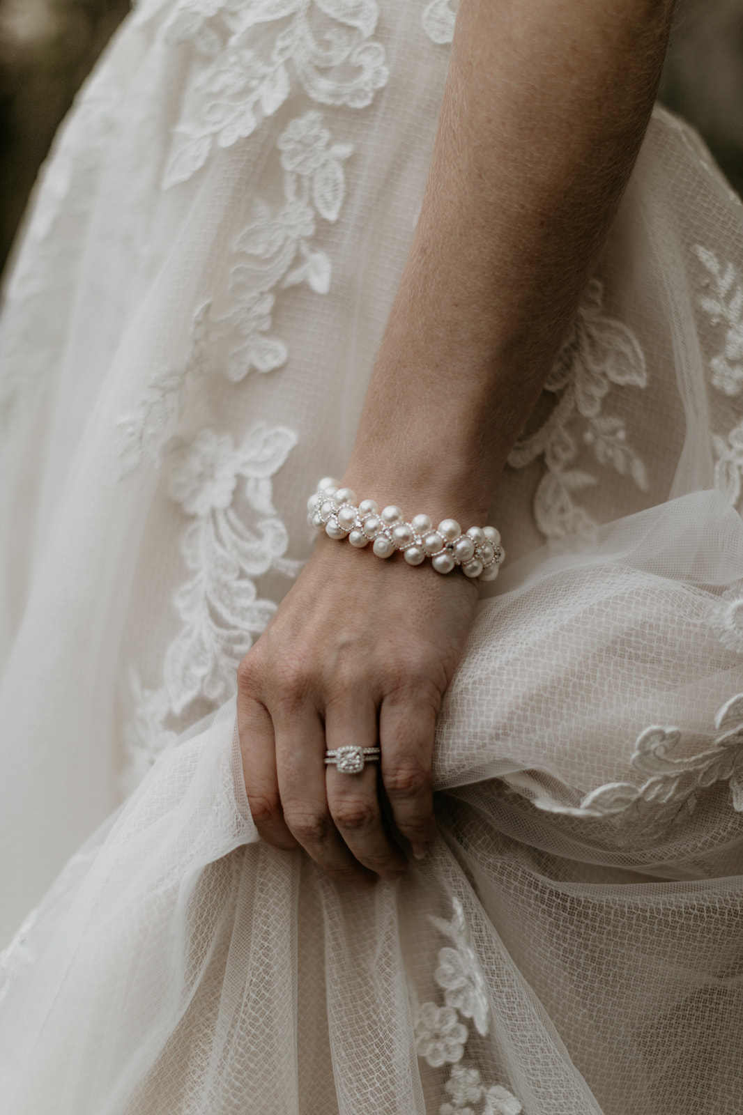 Bride wears pearl bracelet against lace gown on Vancouver Island