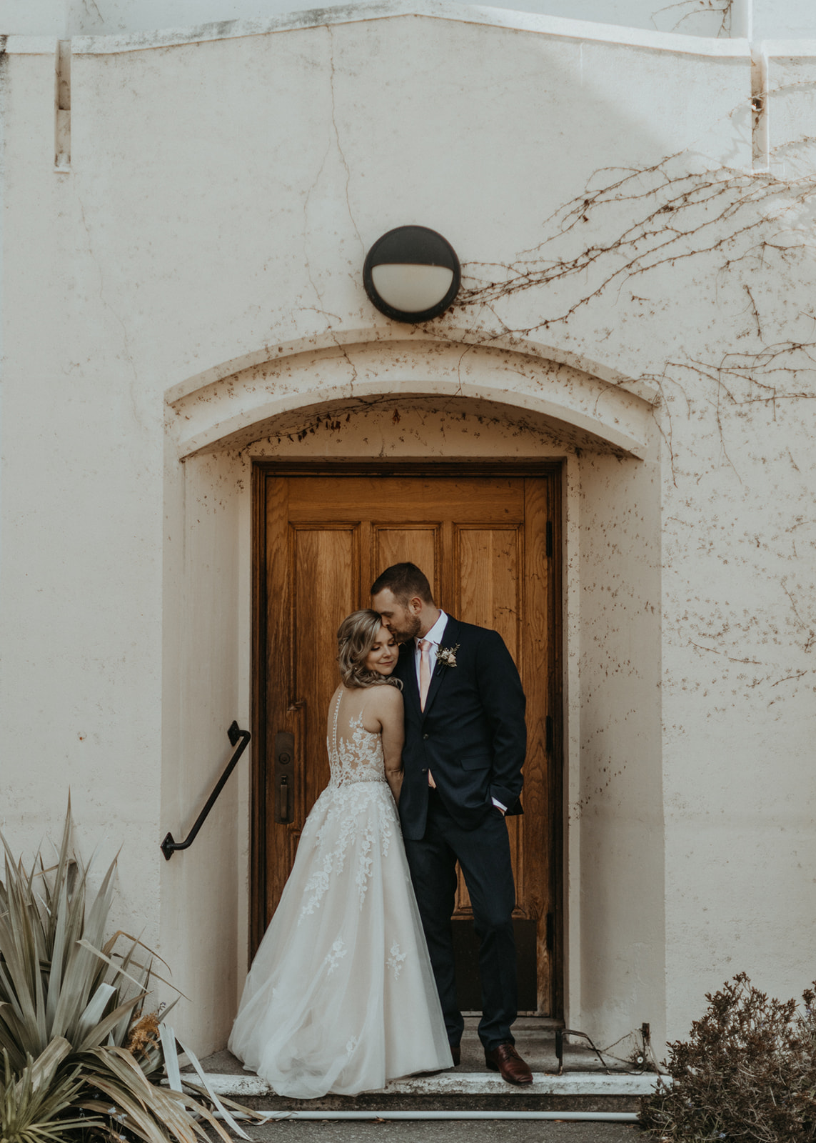 Newlyweds stand together in front of Church Door on Vancouver Island