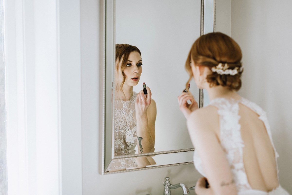 Sophisticated Bride applies lipstick reflected in the mirror Vancouver Island Wedding