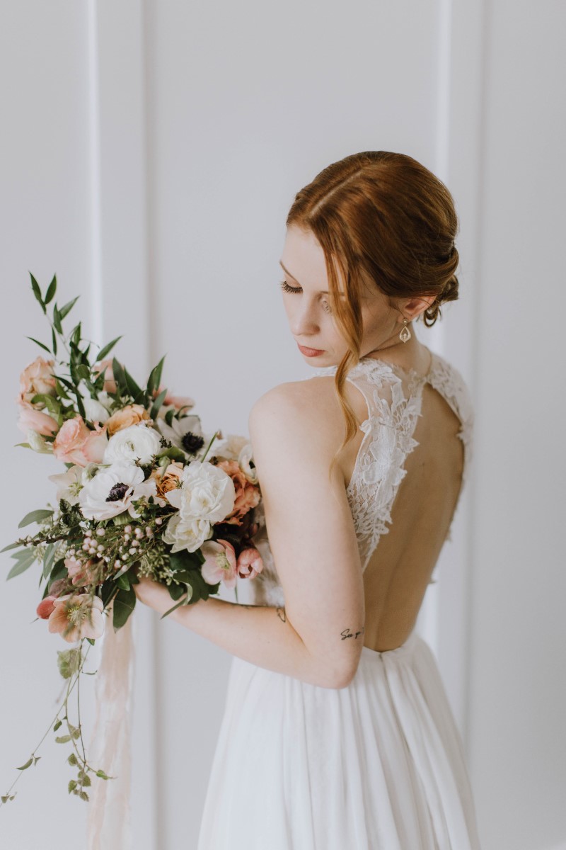 Bride with red hair in chignon and lace cutout back wedding gown