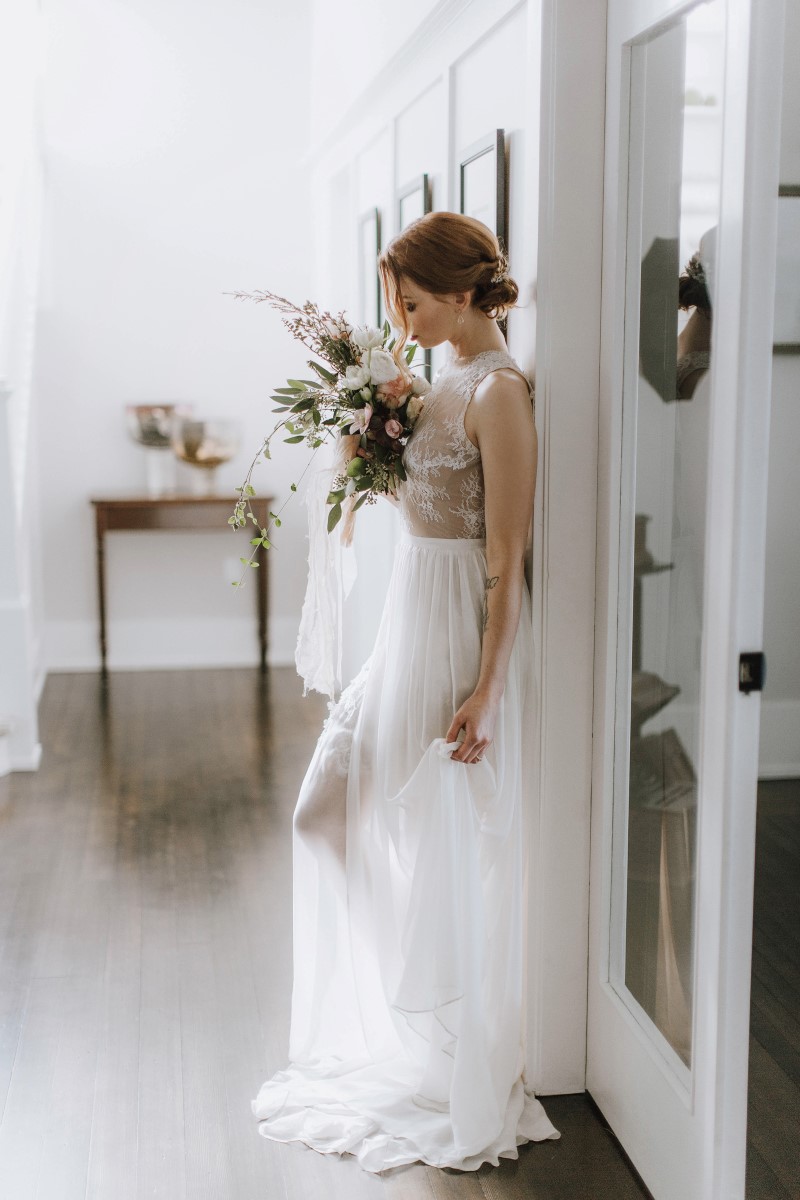 Sophisticated Bride in lace gown and carrying bouquet of greenery and white anemones