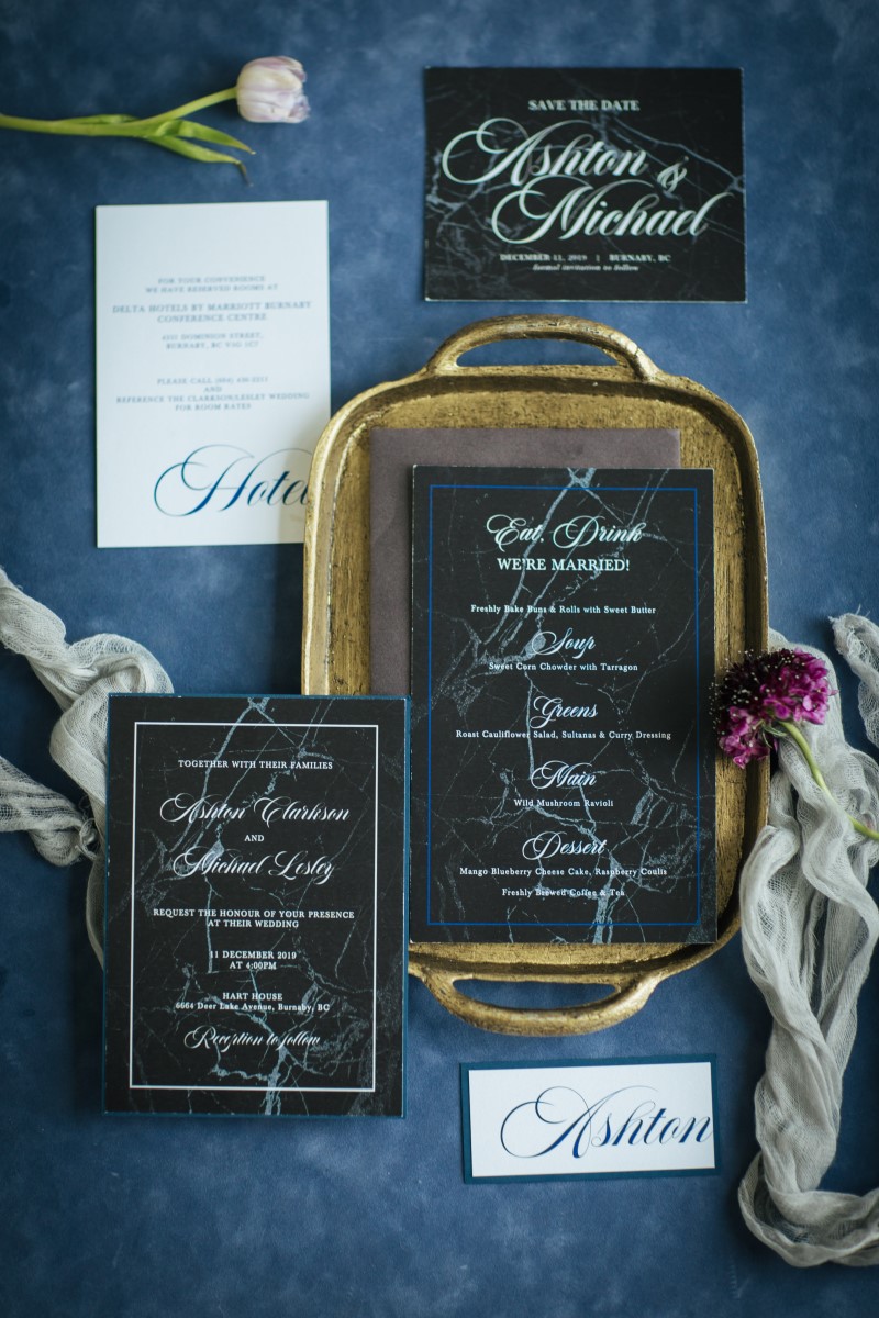 Paper Suite in black with white calligraphy set on rich blue fabric