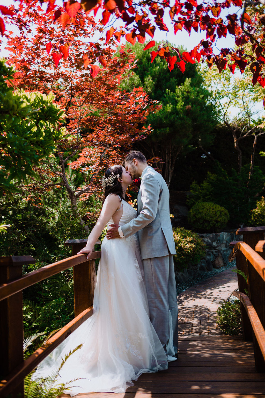 Happily Ever After Newlyweds kiss on Arbutus Ridge Garden Bridge on Vancouver Island