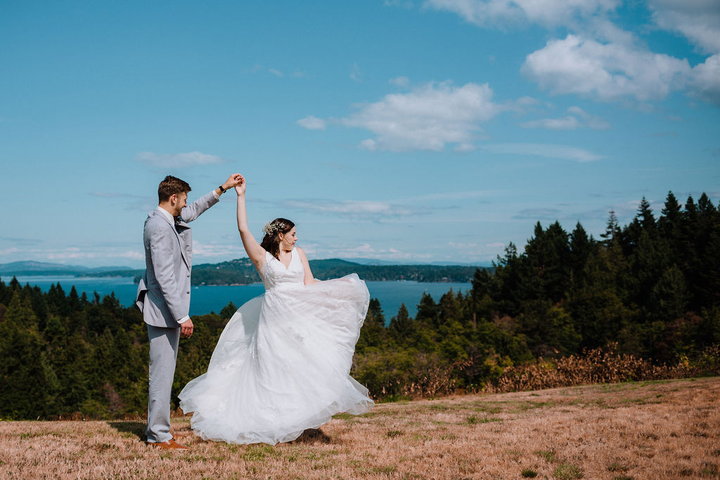 Groom twirls his bride along the ocean of Vancouver Island