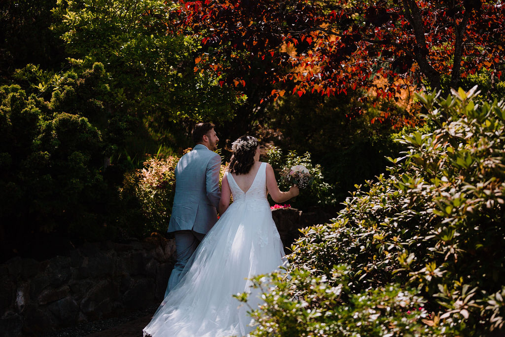 Bride with long flowing white gown with train in Arbutus Ridge gardens