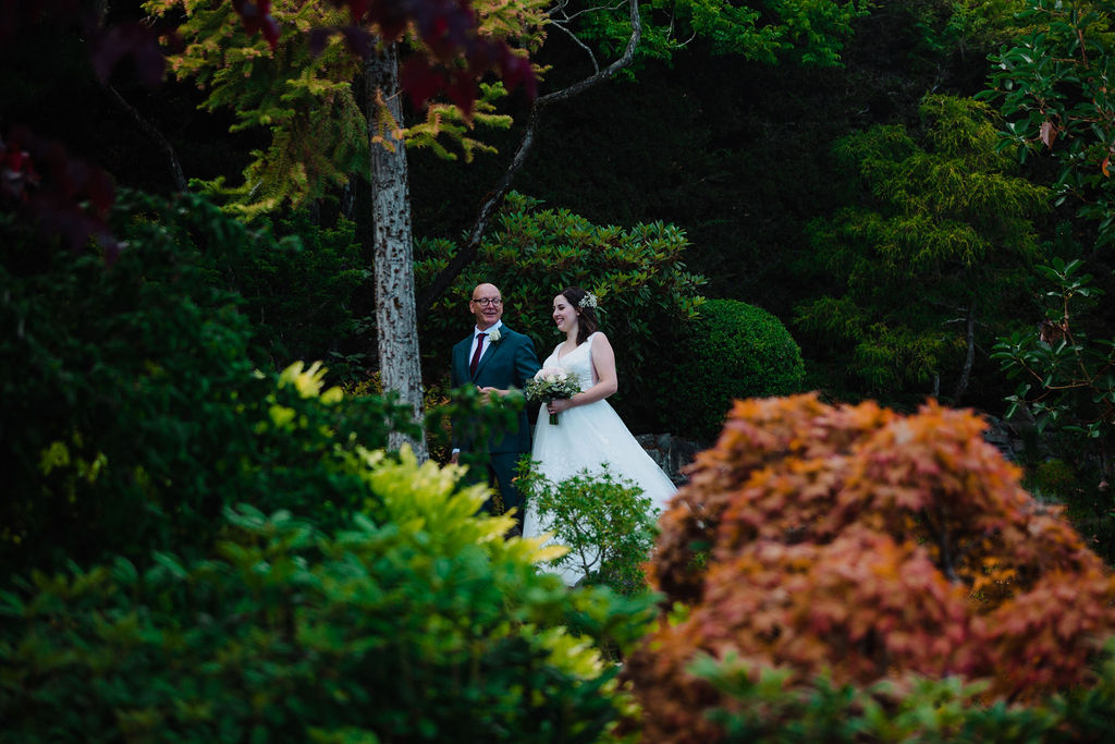 Bride is walked down garden steps to her ceremony at Arbutus Ridge