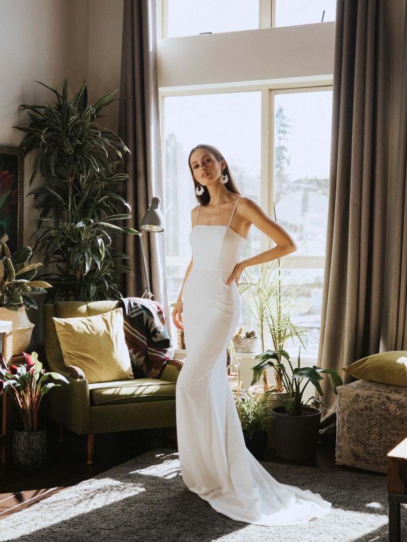 Bride in strapless gown in front of window