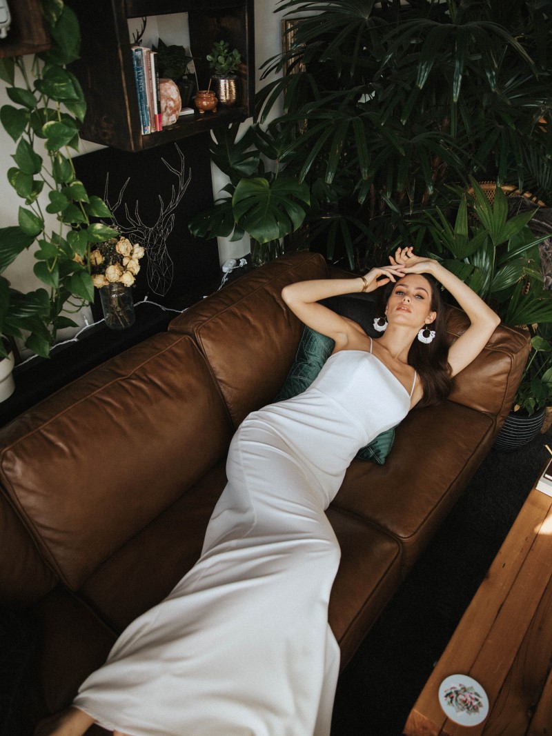 Bride in custom made gown lies on couch