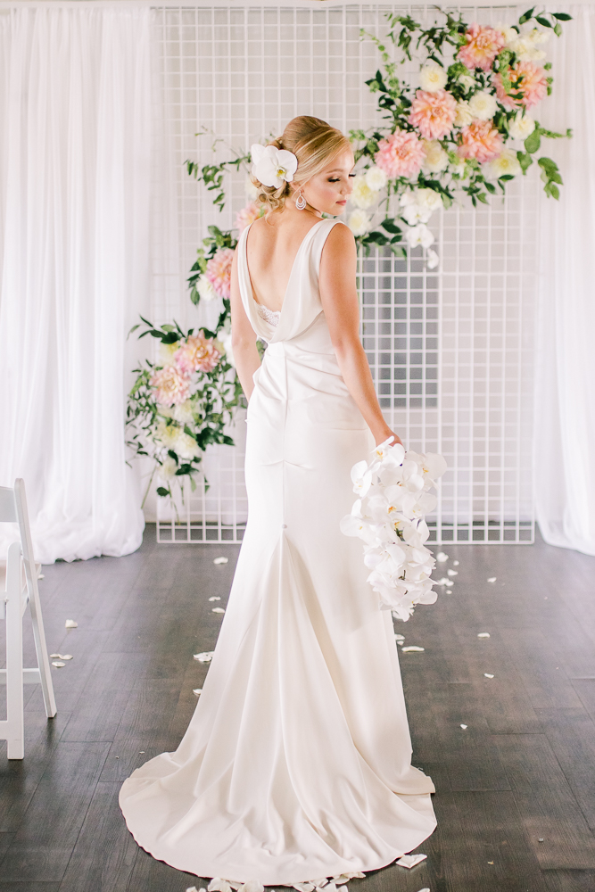 Bride wears Grecian inspired gown from The Dressy Attic in Vancouver and carries bouquet of white orchids