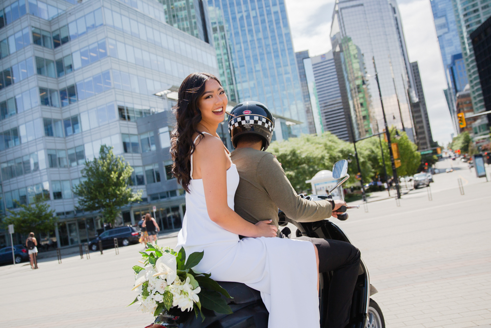 Bride smiles as she is driven on bike down Vancouver streets