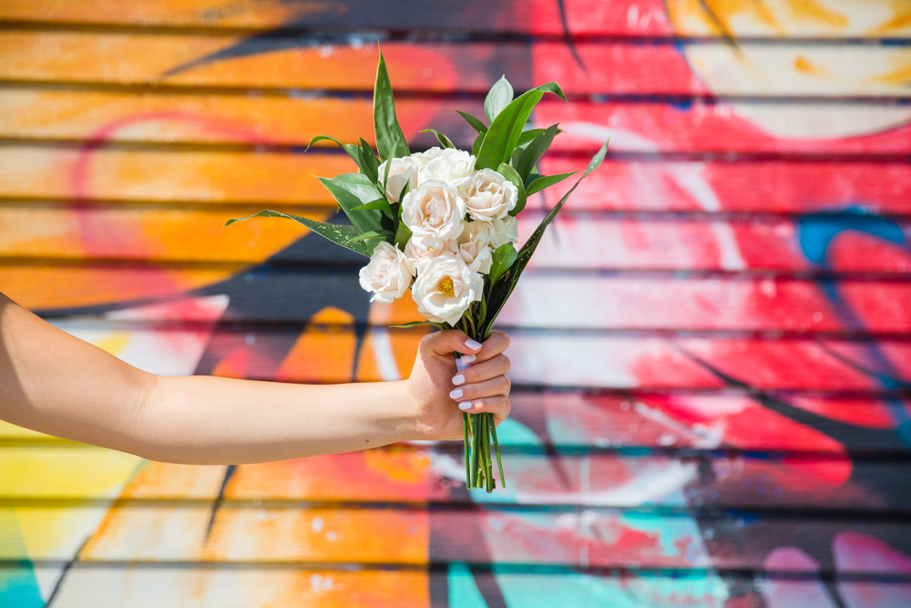 Bridal flowers by Karen Wazny in front of graffiti in Vancouver