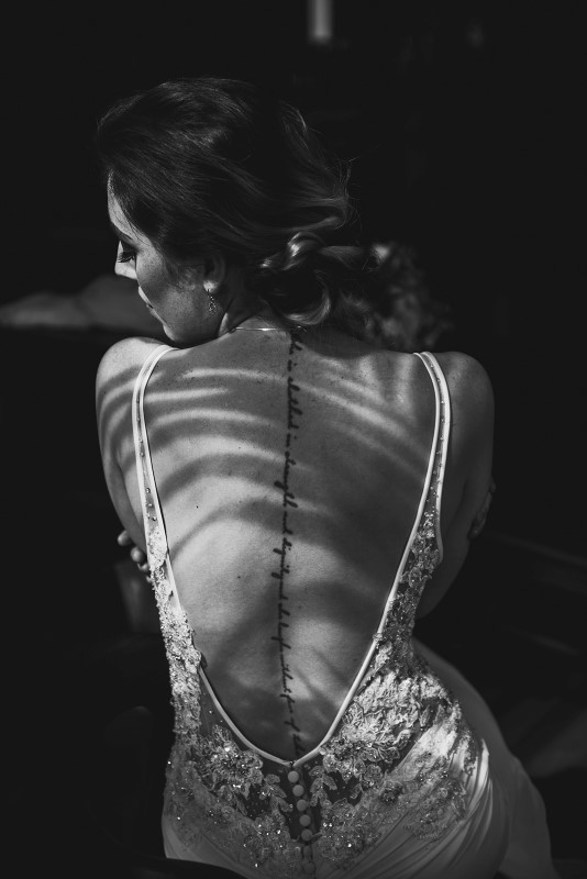 Bride with back tattoo in shadows in black and white shot at Fairmont Empress