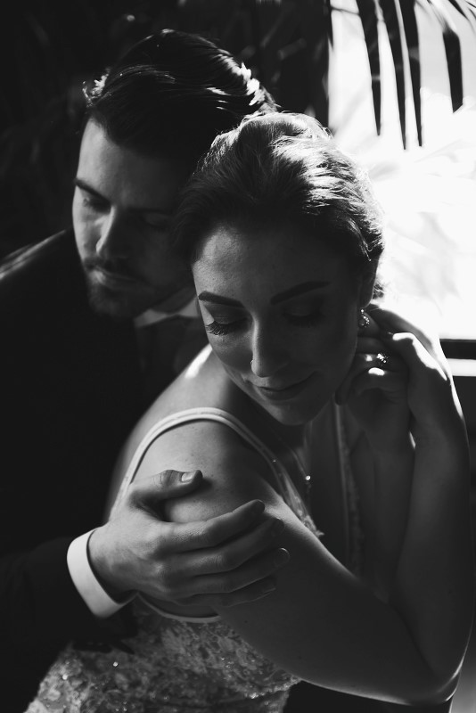 Groom hugs his bride in Fairmont Empress black and white shot