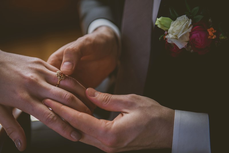 Bride and Groom hold hands looking at ring by Emma Glover Designs on Vancouver Island KGoodPhoto 