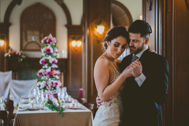 Newlyweds in front of reception table covered in tropical flowers at Fairmont Empress