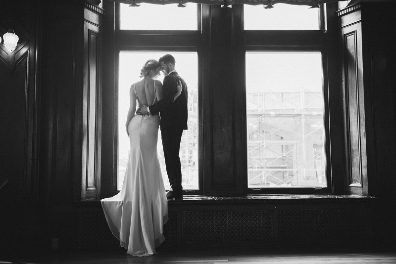 Couple look out Fairmont Empress window by KgoodPhoto