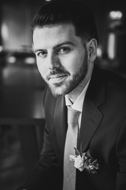 Groom shows off pocked boutonniere by Brown's the Florist while wearing suit from Moore's Clothing for Men at Fairmont Empress